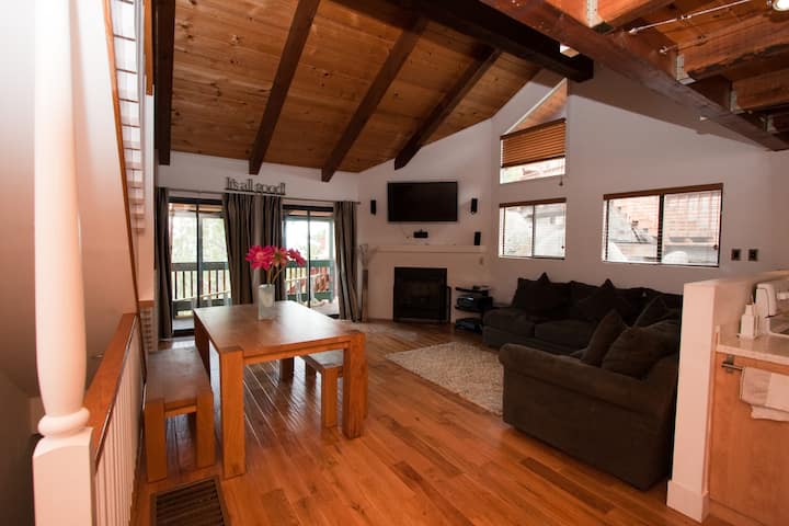 Living room with an L-shaped couch facing a gas fireplace and a flat screen television